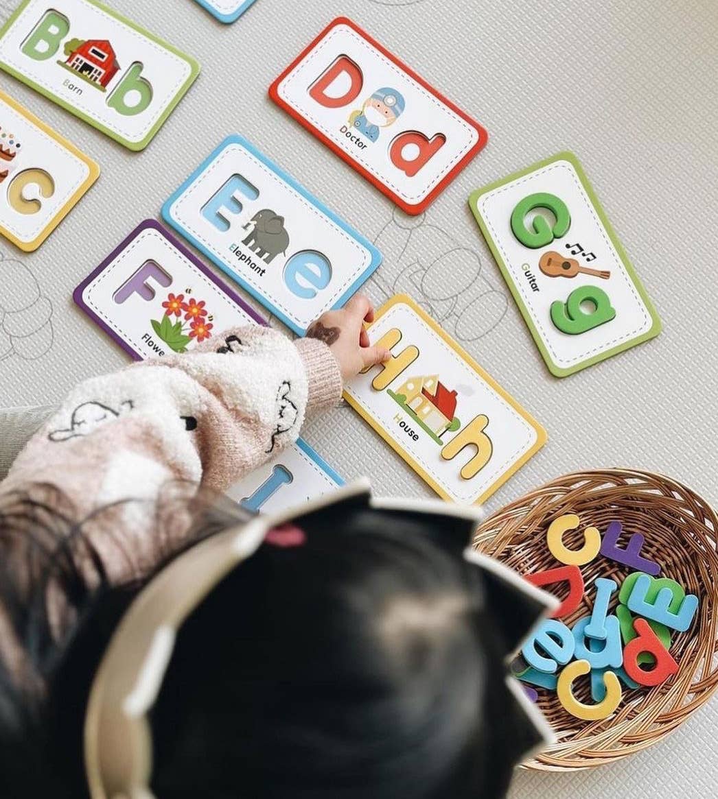 Child playing with alphabet letters on a textured surface