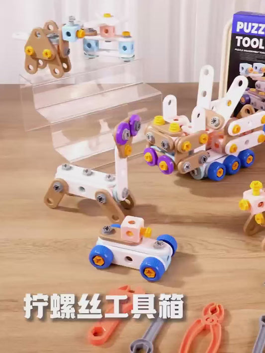 A boy assembling a small robot with a toy hammer in a bright workshop setting, surrounded by colorful building blocks, loose parts, an instruction booklet, and a pegboard with tools. Lulliyo